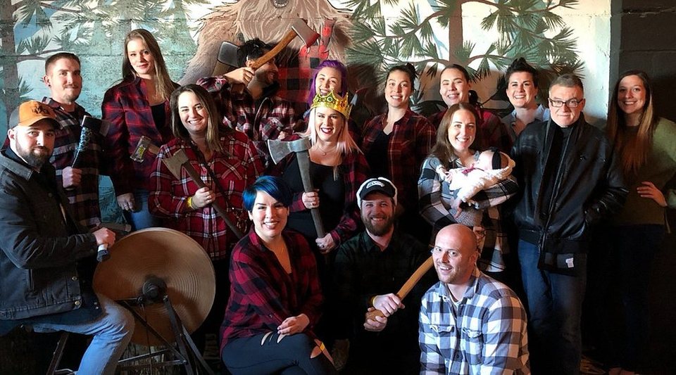 A corporate group posing with axes at Axe Kickers