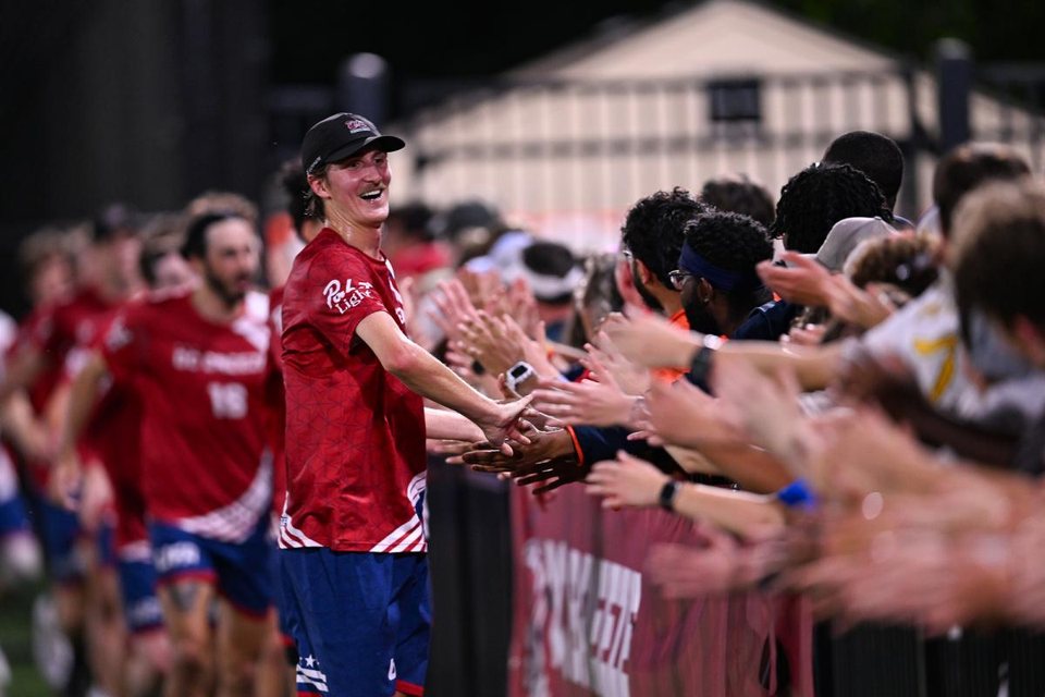 A DC Breeze player high-fiving fans after a match